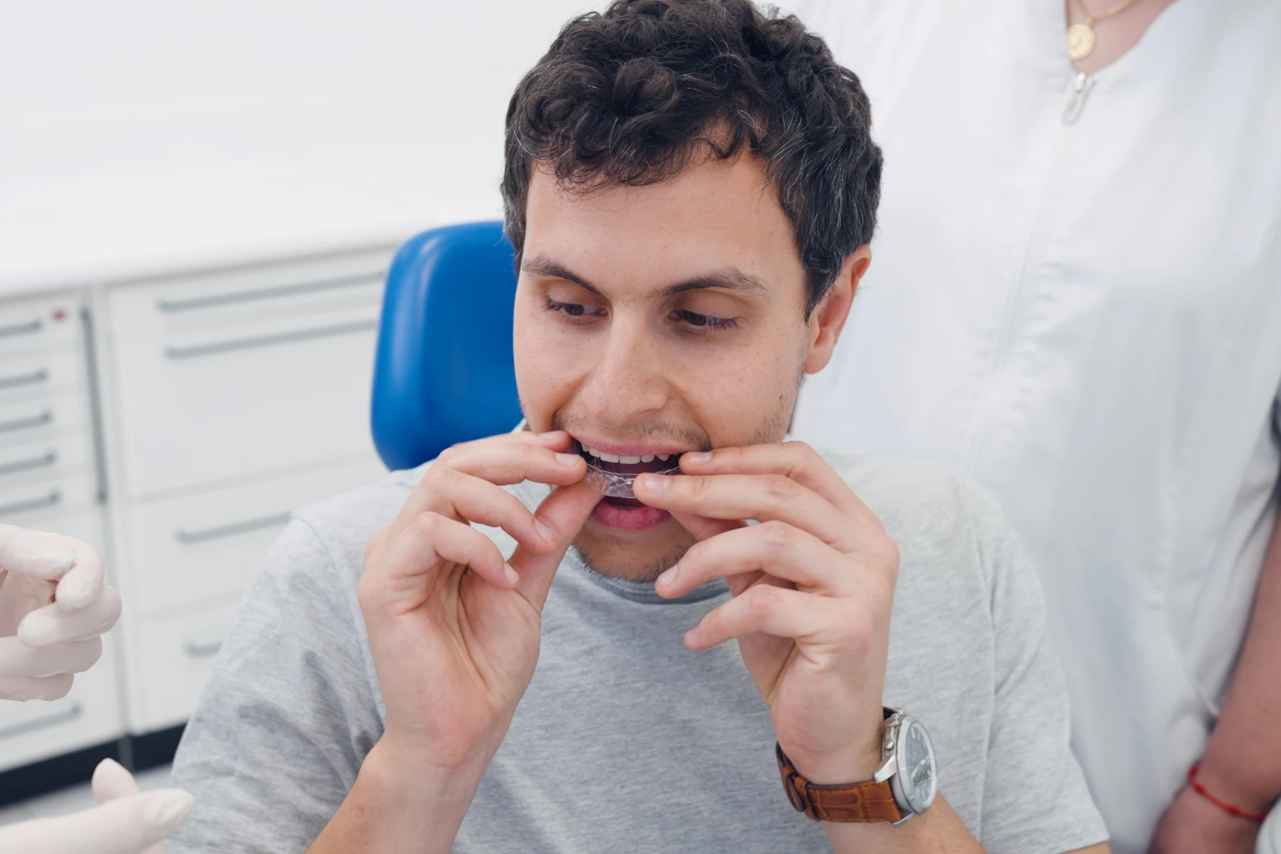 A man applying clear aligners in a dental setting